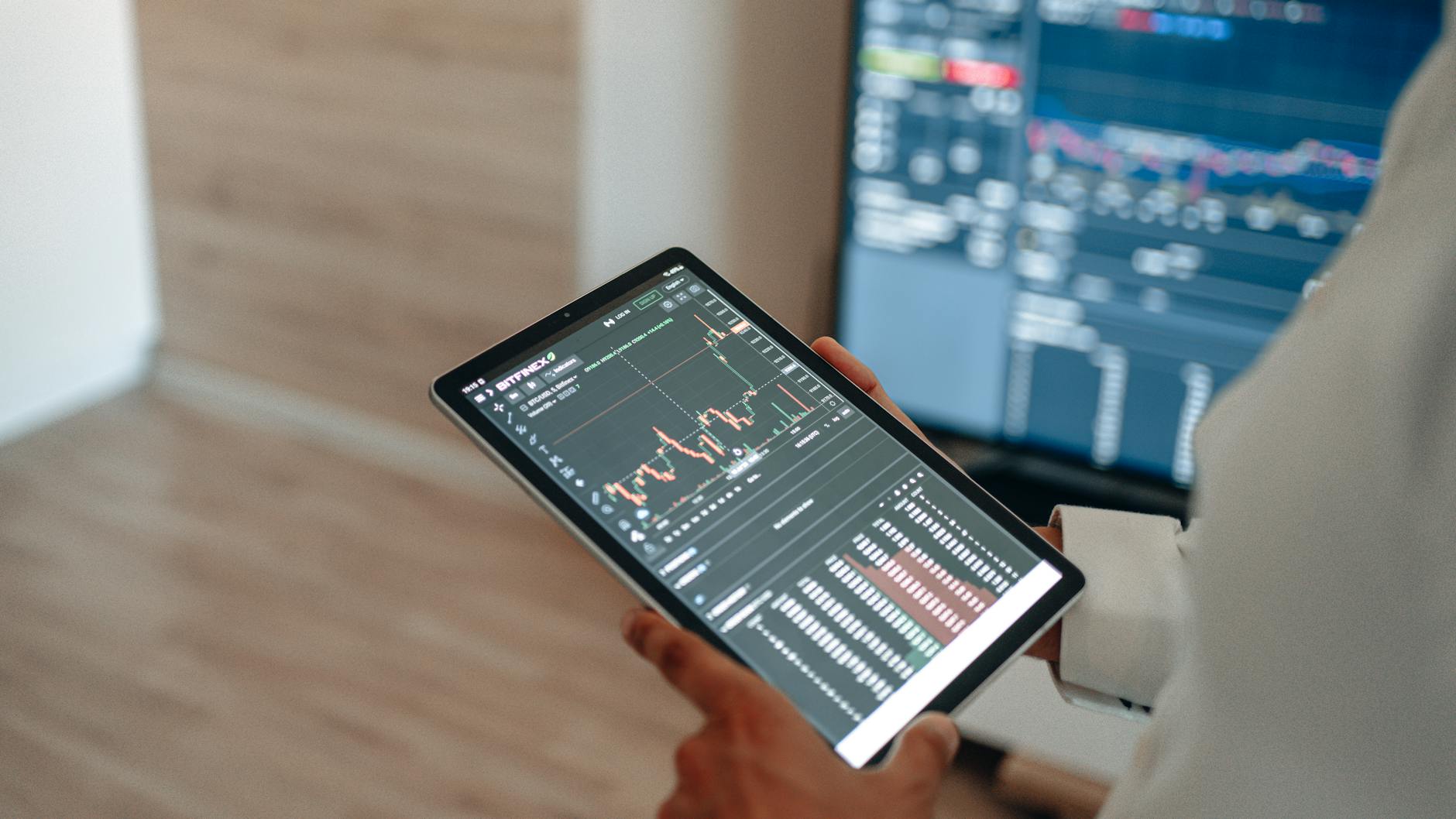 Analityk śledzi na tablecie wykresy giełdowe i aktualne trendy finansowe