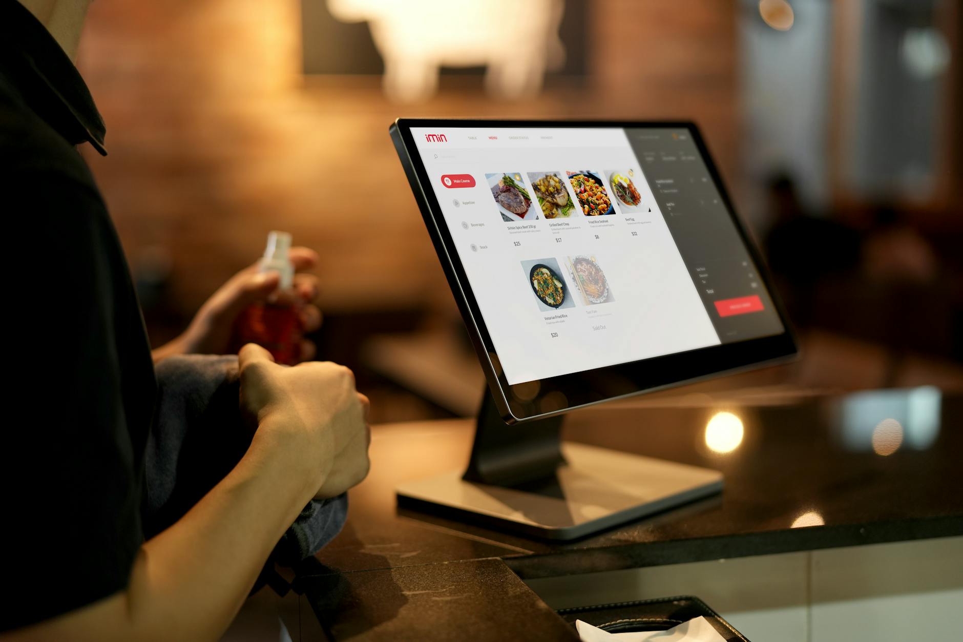 Osoba składa zamówienie na ekranie dotykowym w nowoczesnej restauracji