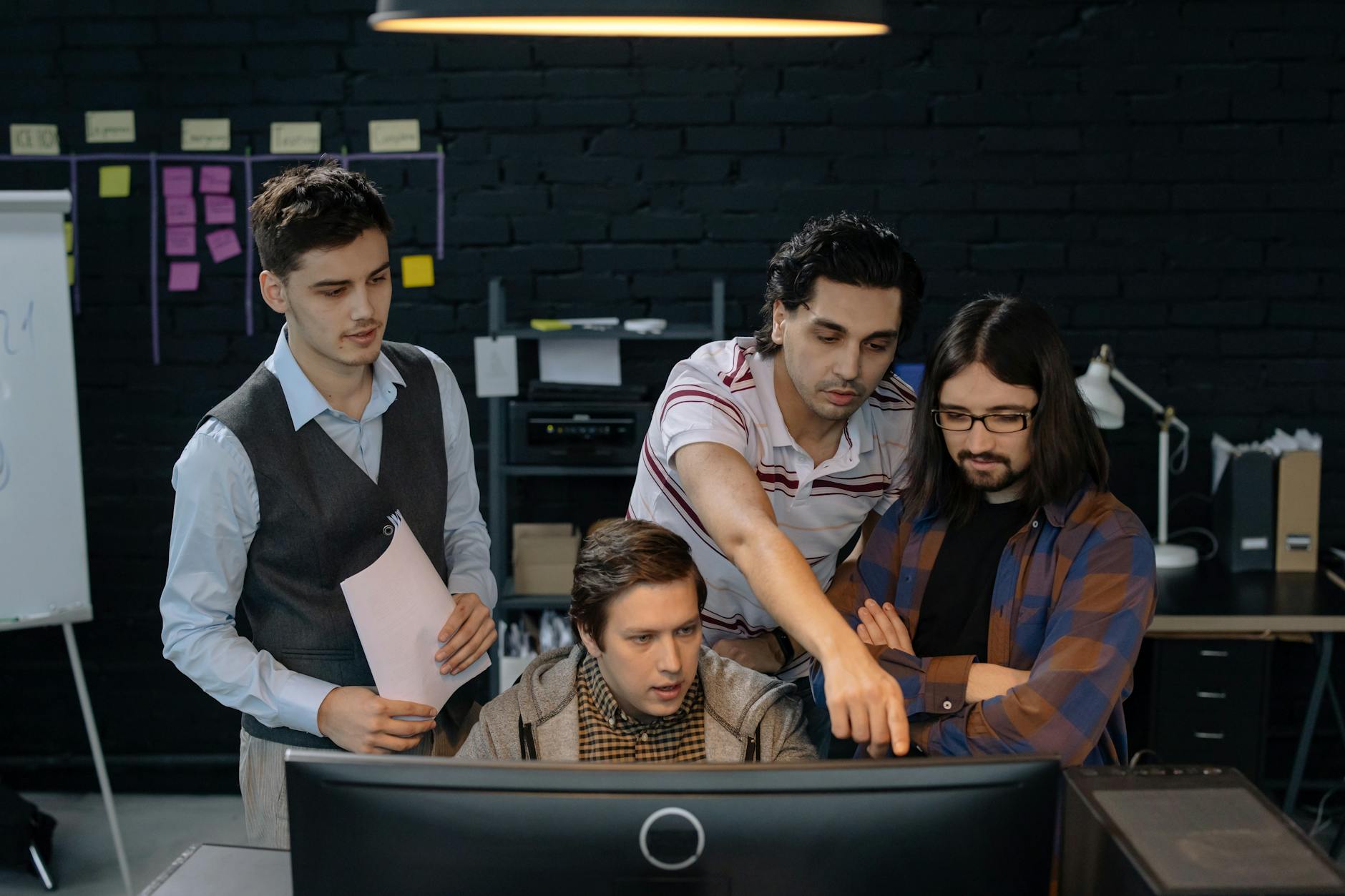 Zespół specjalistów omawia projekt ERP przy komputerze w biurze