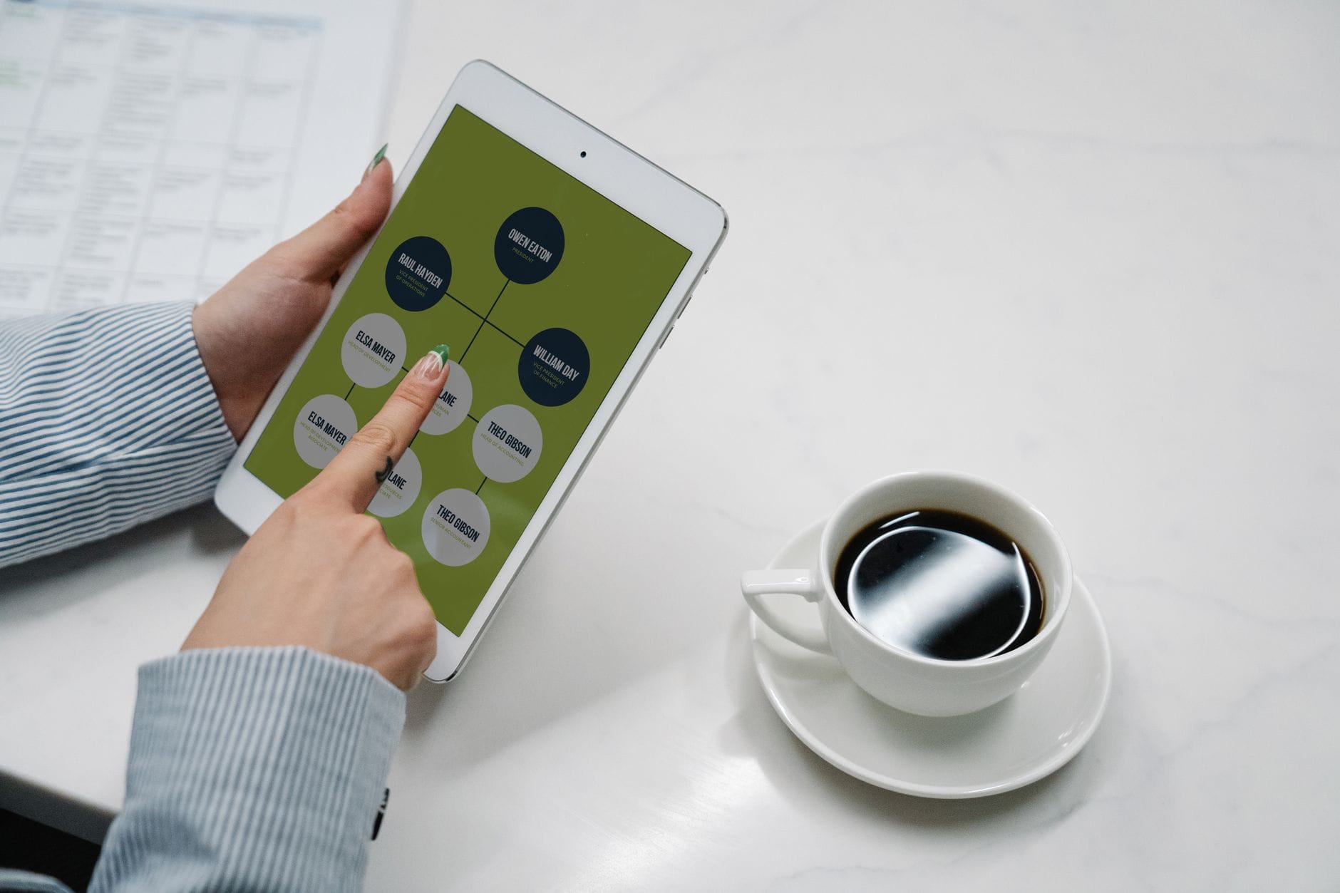 Tablet z diagramem przepływu informacji na biurku obok filiżanki kawy