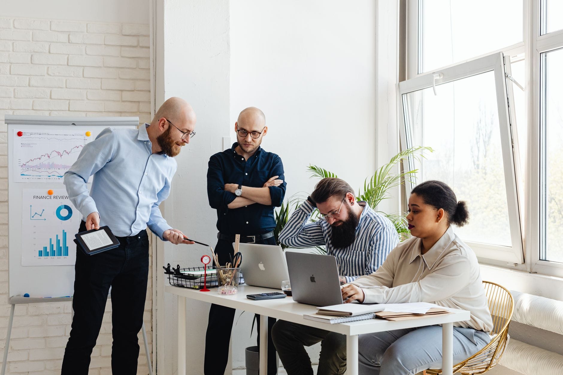 Zespół projektowy omawia strategię wdrożenia systemu ERP przy laptopach