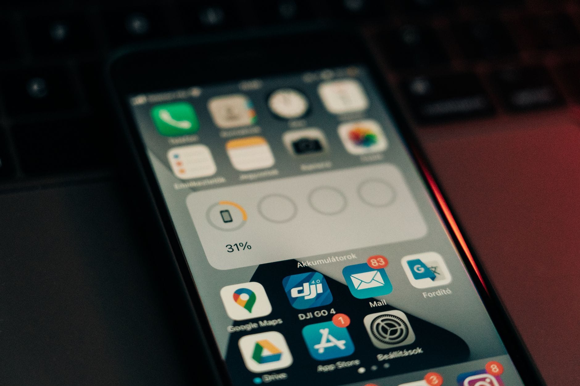 Smartfon z aplikacjami na ekranie leżący na klawiaturze, 31% baterii
