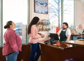 Jak zintegrować formularz kontaktowy z CRM i nie gubić zapytań Klienci rozmawiają z obsługą przy ladzie restauracji