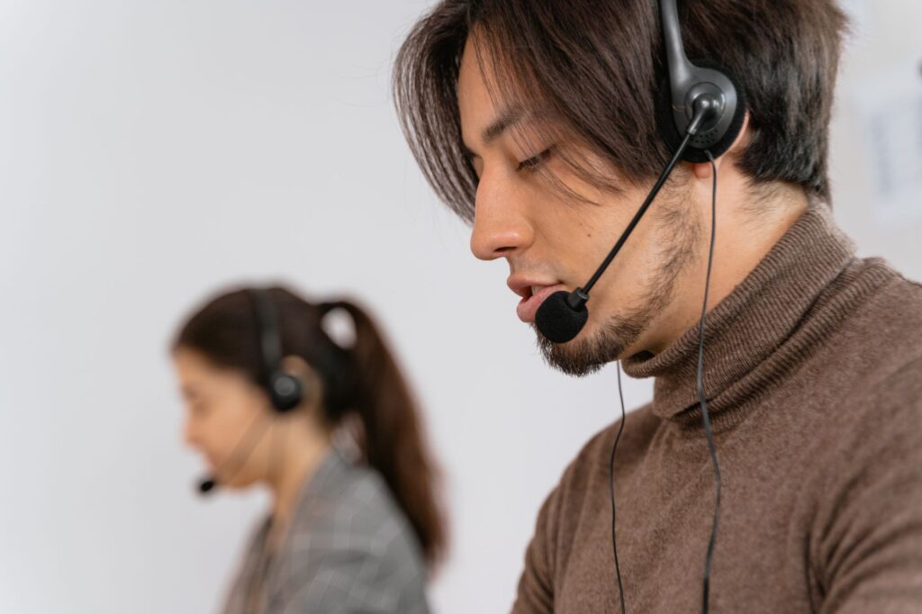 Pracownicy call center w słuchawkach obsługujący klientów